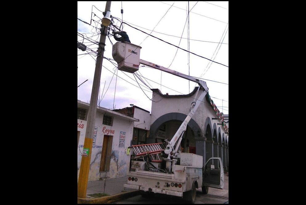 Trabajadores de la CFE suspenden el suministro de energía eléctrica al palacio municipal desde un poste cercano al edificio de gobierno. Foto Especial
