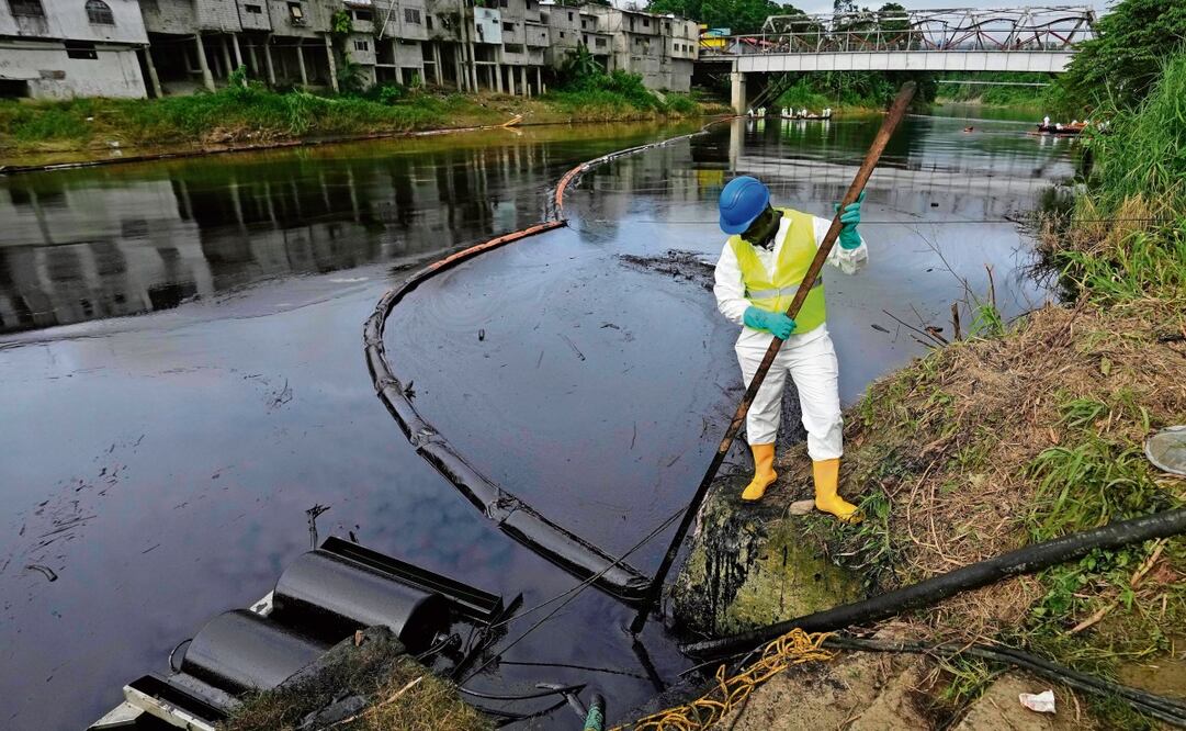 Un trabajador de la compañía petrolera estatal limpia el río Viche en Ecuador, luego de que se contaminó debido a un derrame de crudo provocado por un deslave que fracturó un oleoducto. Foto: Dolores Ochoa / AP