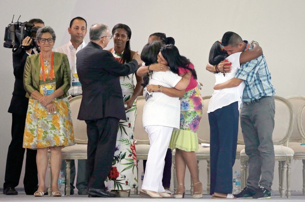 Víctimas y victimarios del conflicto interno de Colombia se abrazaron el viernes, durante una reunión de oración por la reconciliación en Villavicencio. (RICARDO MAZALAN. AP)