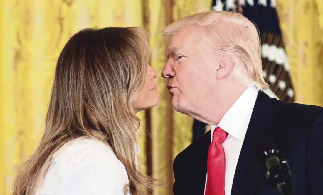 El presidente de Estados Unidos, Donald Trump, besó ayer a la primera dama, Melania Trump, durante la celebración de madres militares en la Casa Blanca, en Washington. (YURI GRIPAS. REUTERS)