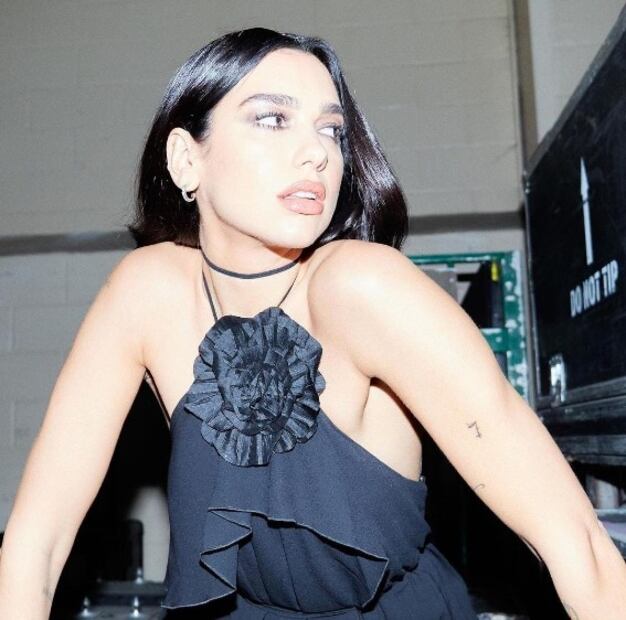 Dua Lipa luce increíble con minivestido negro y botas altas de charol
