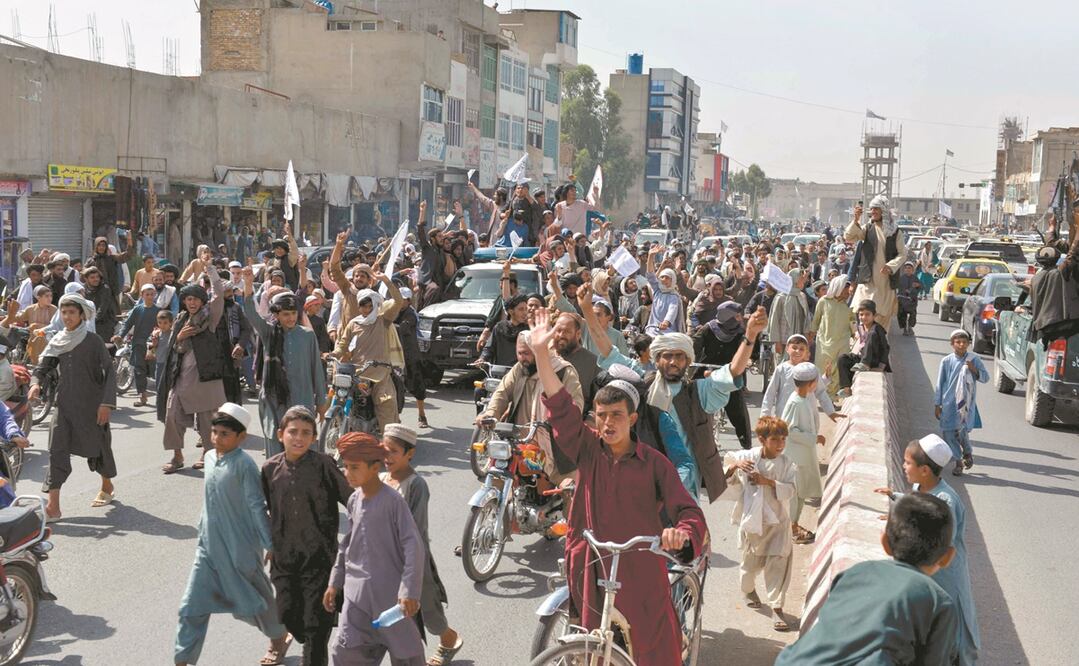 Seguidores de los talibanes gritan consignas y ondean banderas, mientras marchan por una calle en Kandahar al celebrar, después de que Estados Unidos ret i ró a todas sus tropas del país para poner fin a un conflicto bélico de 20 años. Foto: AFP