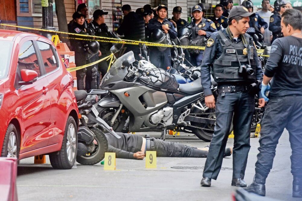 Policías de Investigación resguardaron el área donde quedó tendido el cuerpo de un presunto delincuente que participó en el robo a un local de telefonía. (EDUARDO SÁNCHEZ. EL UNIVERSAL)