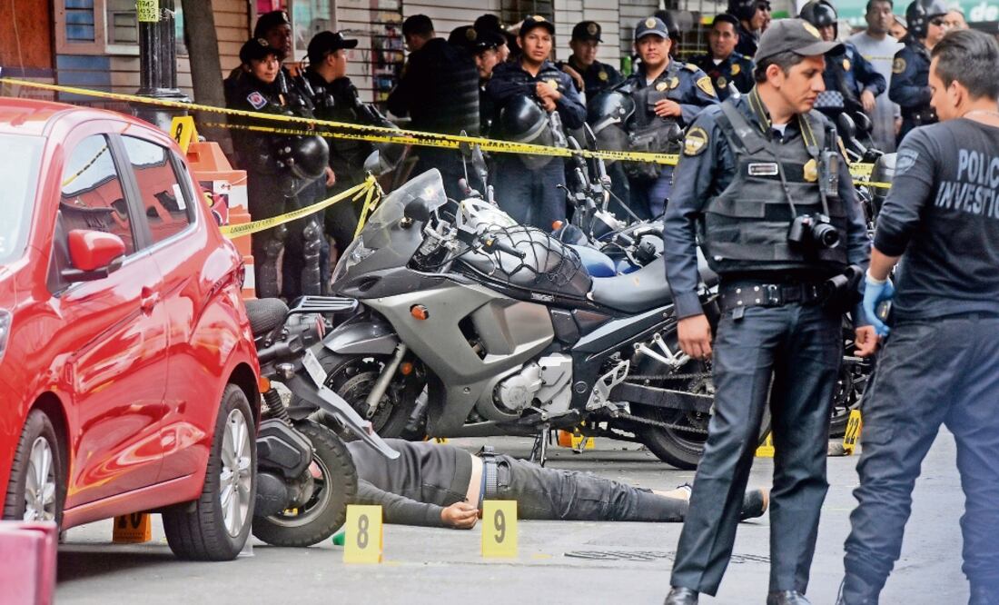 Policías de Investigación resguardaron el área donde quedó tendido el cuerpo de un presunto delincuente que participó en el robo a un local de telefonía. (EDUARDO SÁNCHEZ. EL UNIVERSAL)