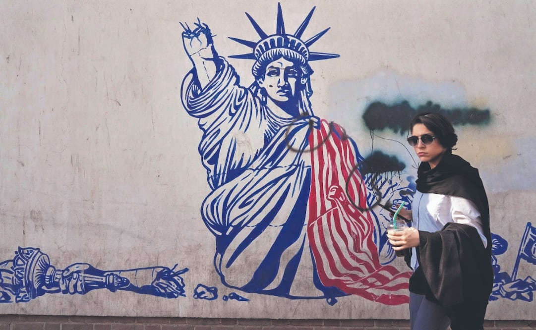 Una joven pasa junto a un mural antiestadounidense en la pared de la antigua Embajada de Estados Unidos, ahora convertida en museo, en Teherán. Foto: Vahid Salemi/AP