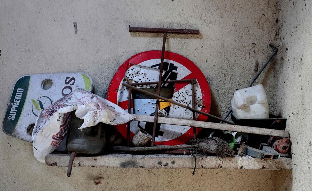 Varios objetos en los que destaca un letrero de señalización que sirvió para practicar tiro al blanco. Foto: AFP