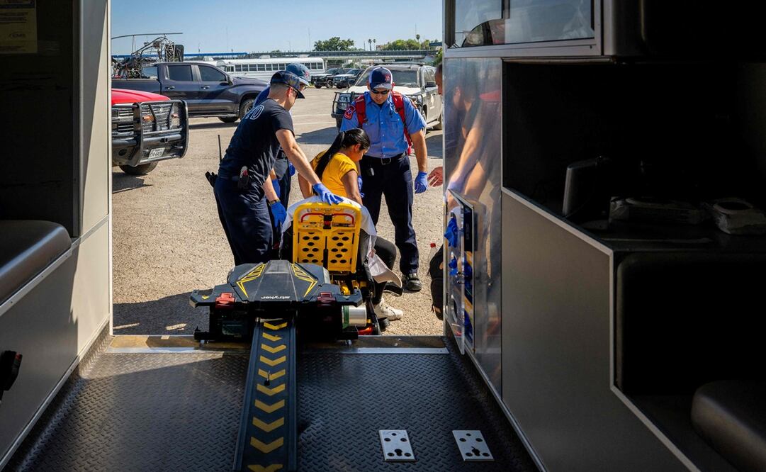 Los técnicos médicos de emergencia de Eagle Pass atienden a una mujer embarazada que sufre de deshidratación en Texas. Foto: AFP