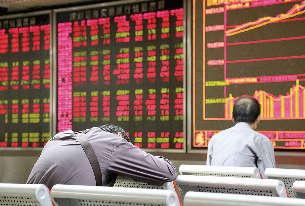 Inversionistas chinos ayer frente a la pizarra de cotizaciones en Beijing, China (REUTERS)