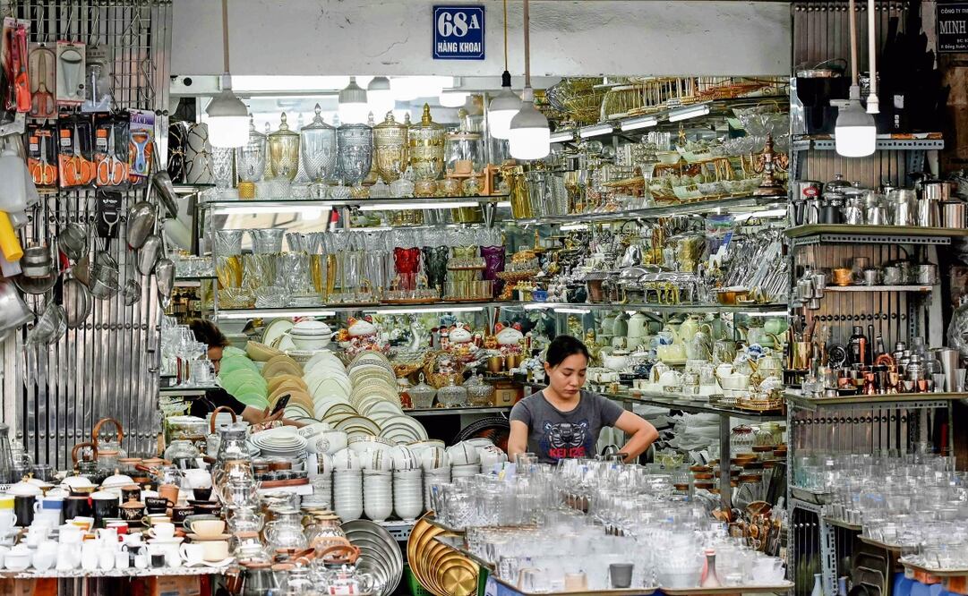 Una vendedora usa su teléfono mientras espera clientes en una tienda de electrodomésticos en Hanói. Vietnam llegó el miércoles a un pacto arancelario con Estados Unidos. Foto: Nhac Nguyen / AFP