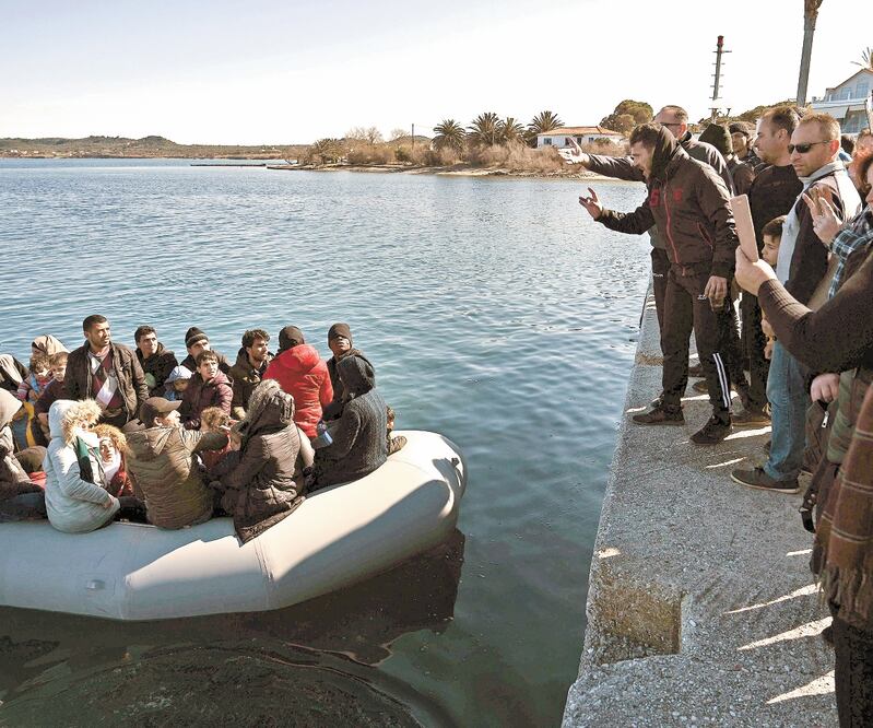 Migrantes llegaron a bordo de un bote inflable a la isla de Lesbos, en Grecia, aunque no fueron bien recibidos por los residentes locales. Foto: ARIS MESSINIS. AFP