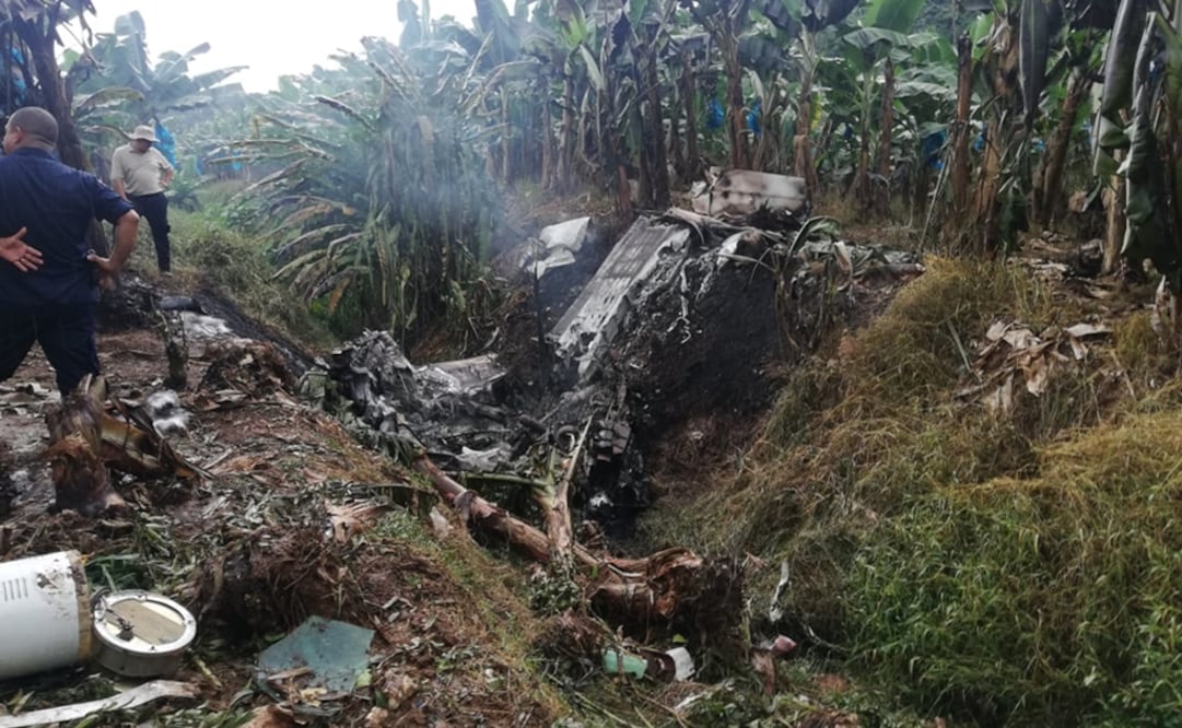 Dos hombres observan los restos de una avioneta que se accidentó este martes en una plantación bananera en la zona del Caribe de Costa Rica y que estaría ligada al narcotráfico en México. Foto: Pegando Porte y La Vara.