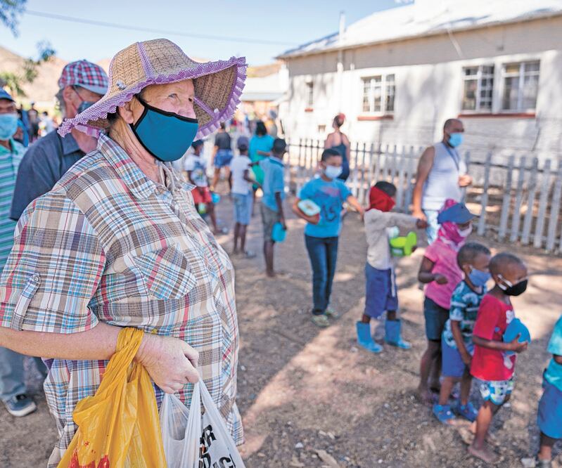 Sudafr icanos esperan para recibir comida de una ONG en Touwsrivier. El gobierno quiere cambiar la vacuna de Astra Zeneca por la de Johnson & Johnson. EFE