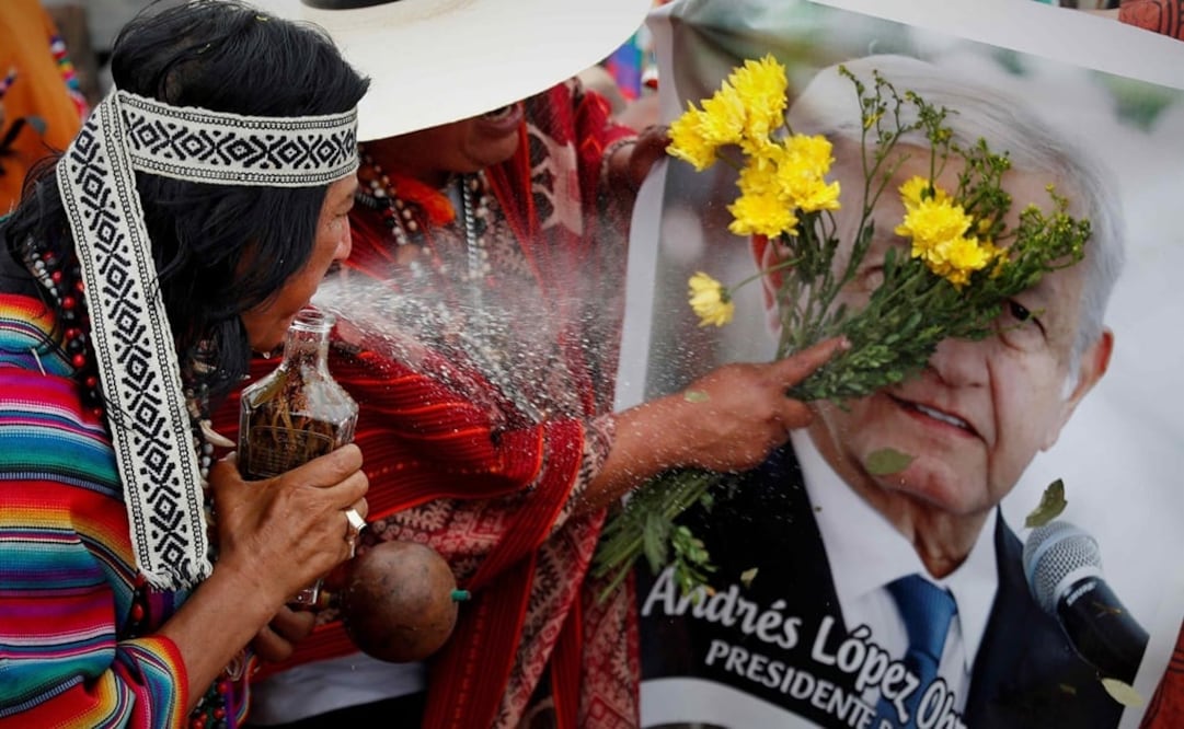 Chamanes y curanderos peruanos sostienen una imagen de López Obrador, durante la ceremonia en que hacen sus predicciones para el 2022. Foto: EFE