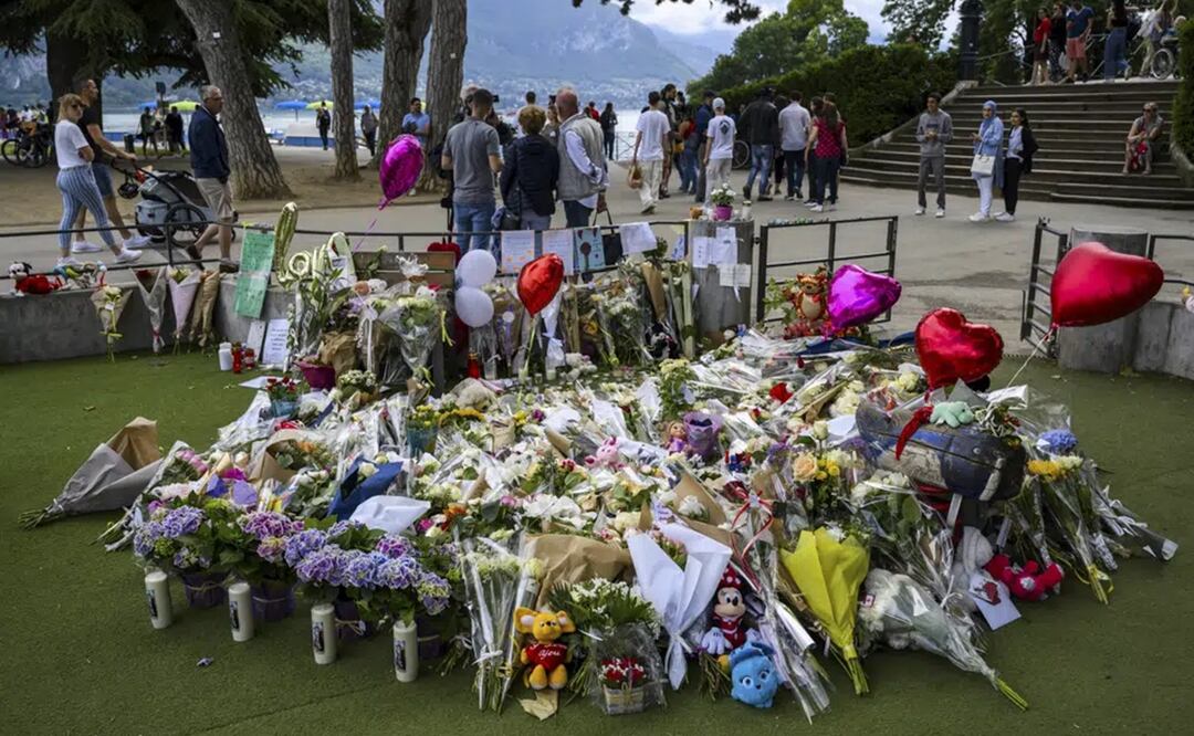 Un grupo de flores, juguetes de peluche y mensajes de apoyo forman un monumento improvisado en la superficie acolchada de un patio de recreo infantil en Annecy, Francia. Foto: AP