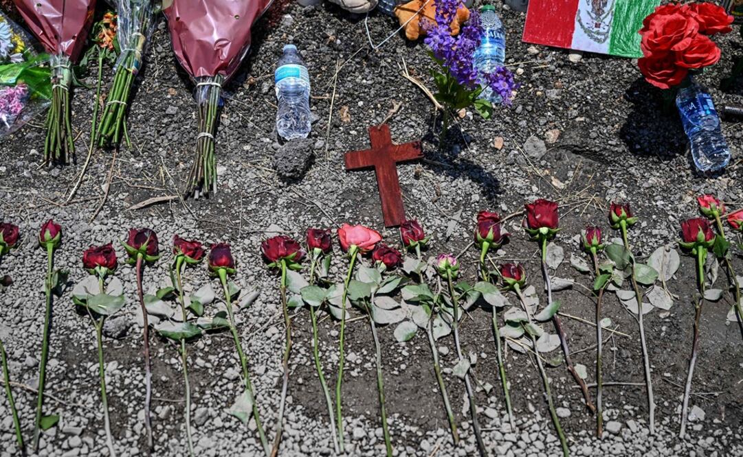 Las flores se exhiben en un monumento improvisado en el lugar donde se descubrió un camión con remolque con migrantes adentro, en las afueras de San Antonio, Texas. Foto: AFP