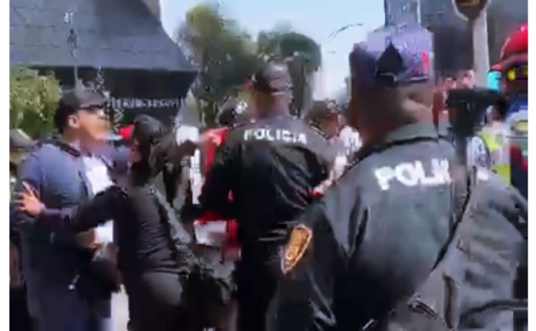 Conato de riña en la Glorieta del Caballito; civiles forcejean con policías durante el desfile de la Revolución. Foto: Especial