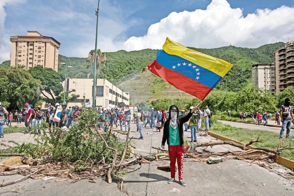 Manifestantes se enfrentaron ayer con miembros de la Guardia Nacional Bolivariana, quienes les impidieron llegar a su destino en Caracas (MIGUEL GUTIÉRREZ. EFE)