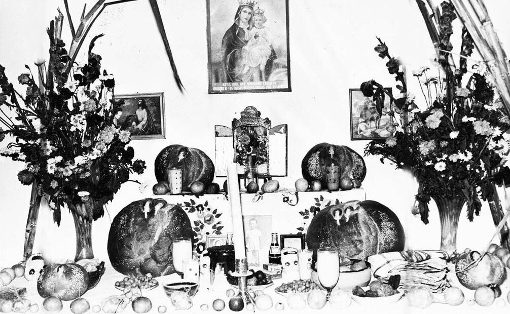 Presentación de una ofrenda de los años noventa, en la que destaca el pan de muerto de yema, con sus típicos rostros en la parte superior. Foto: Archivo El Universal.