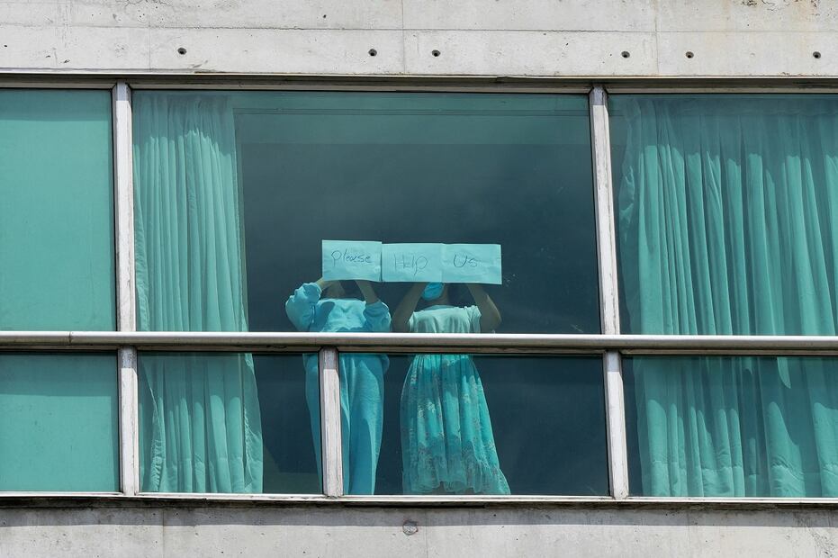 Migrantes deportados de EU colocan papeles con un mensaje escrito en la ventana del Hotel Decápolis donde se hospedan temporalmente en Ciudad de Panamá. FOTO: ARNULFO FRNCO. AFP