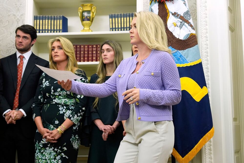 La secretaria de prensa de la Casa Blanca, Karoline Leavitt, se acerca a entregar un documento al presidente Donald Trump mientras Oliver Oz (de izquierda a derecha), Daphne Oz y Zoe Oz observan durante la ceremonia de juramentación del Dr. Mehmet Oz como administrador de los Centros de Servicios de Medicare y Medicaid, en la Oficina Oval de la Casa Blanca, en Washington, el 18 de abril. Foto: AP