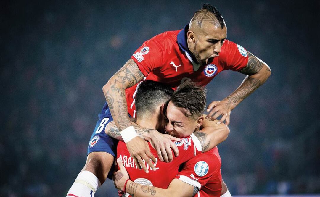 Arturo Vidal cae sobre sus compañeros Eduardo Vargas y Charles Aránguiz para celebrar el gol que lleva a Chile a la final de Copa América, ante el éxtasis del estadio Nacional./Xinhua