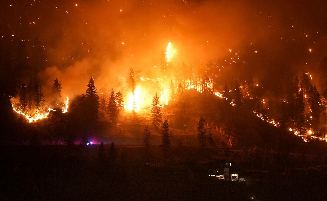 El incendio de McDougall Creek arde en las montañas sobre una vivienda a orillas de un lago en West Kelowna, Canadá. Foto: AP