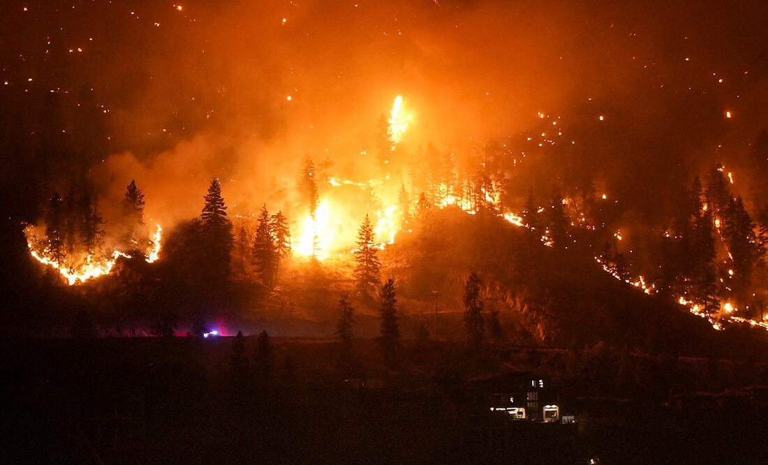 El incendio de McDougall Creek arde en las montañas sobre una vivienda a orillas de un lago en West Kelowna, Canadá. Foto: AP