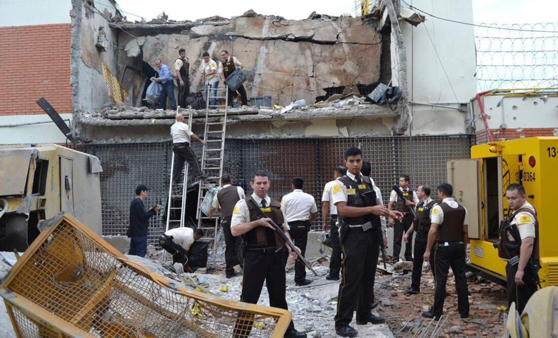 Docenas de atacantes armados con rifles usaron explosivos para volar la puerta de una trasportadora de valores y aparentemente escaparon a Brasil (AP)