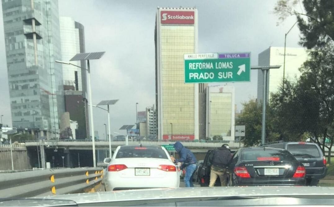 Photo: Still from video showing armed robbers attacking two vehicles during rush hour