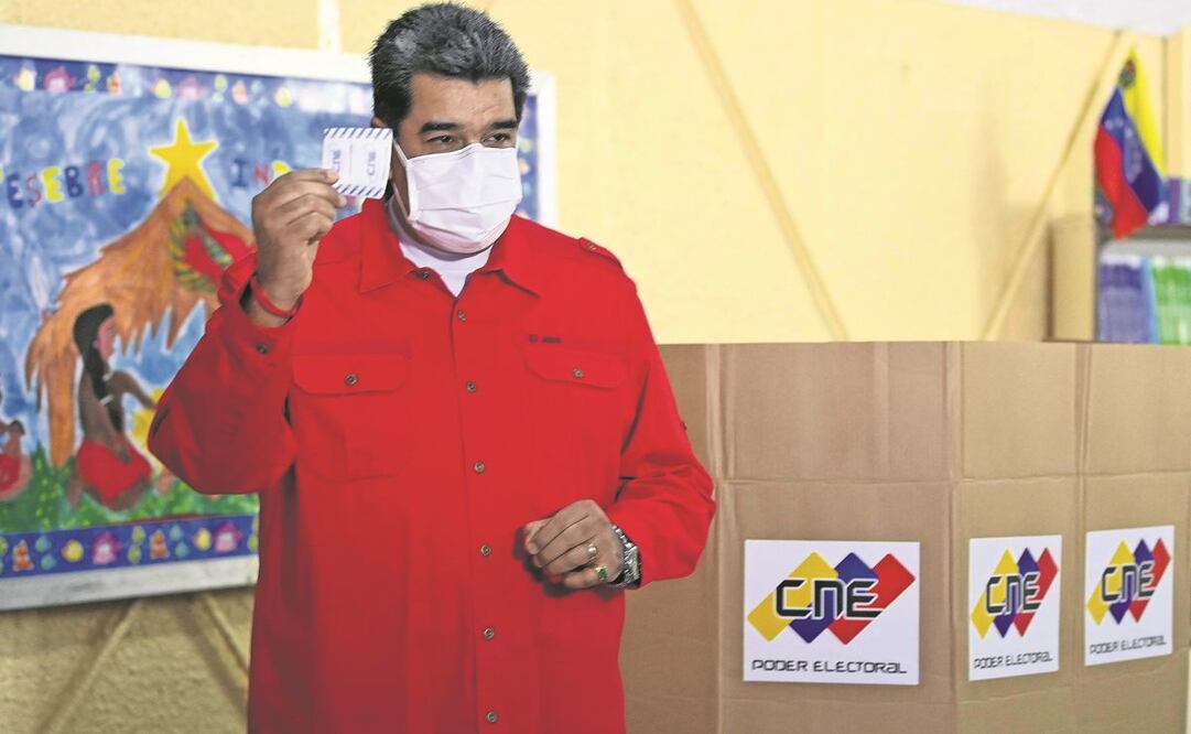 El presidente venezolano Nicolás Maduro muestra su voto, antes de depositarlo. Foto: Yuri Cortez. AFP