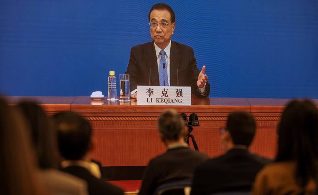 Primer ministro chino, Li Keqiang, se ve en las pantallas mientras habla con los reporteros durante una conferencia de prensa en línea, en Beijing. Foto: EFE 