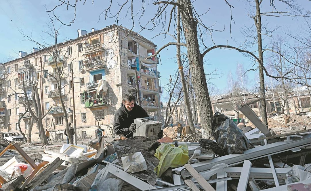 Un ucraniano revisa entre las cosas que sacó de su departamento destruido tras un bombardeo de tropas rusas en Kiev, la capital. Foto: Sergei Supinsky/AFP