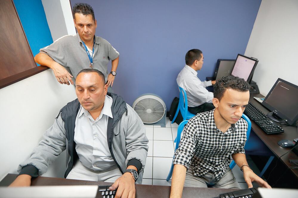 Róger Wellington Muñoz Rivas (sentado) fue deportado en abril pasado tras vivir en Los Ángeles, California; Óscar Eduardo López (de pie) trabajó para Los Zetas, pero hoy es profesor de cómputo (LUIS CORTÉS. EL UNIVERSAL)