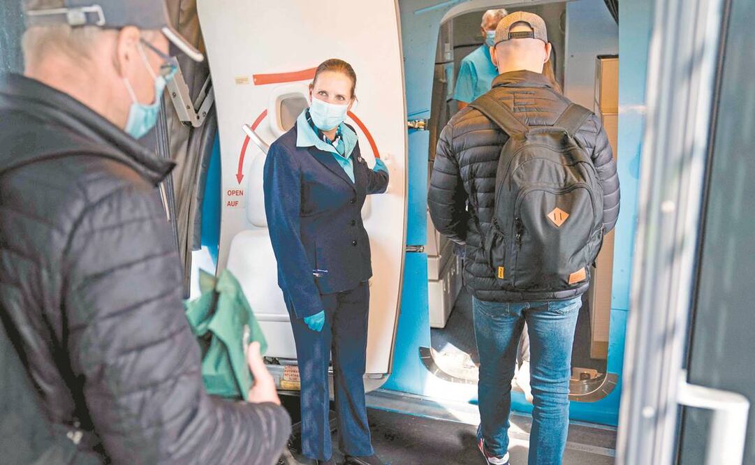 Una azafata da la bienvenida a los pasajeros para su vuelo desde el aeropuerto de Copenhague a la isla turística española de Mallorca. Foto: Martin Sylvest/ AFP.