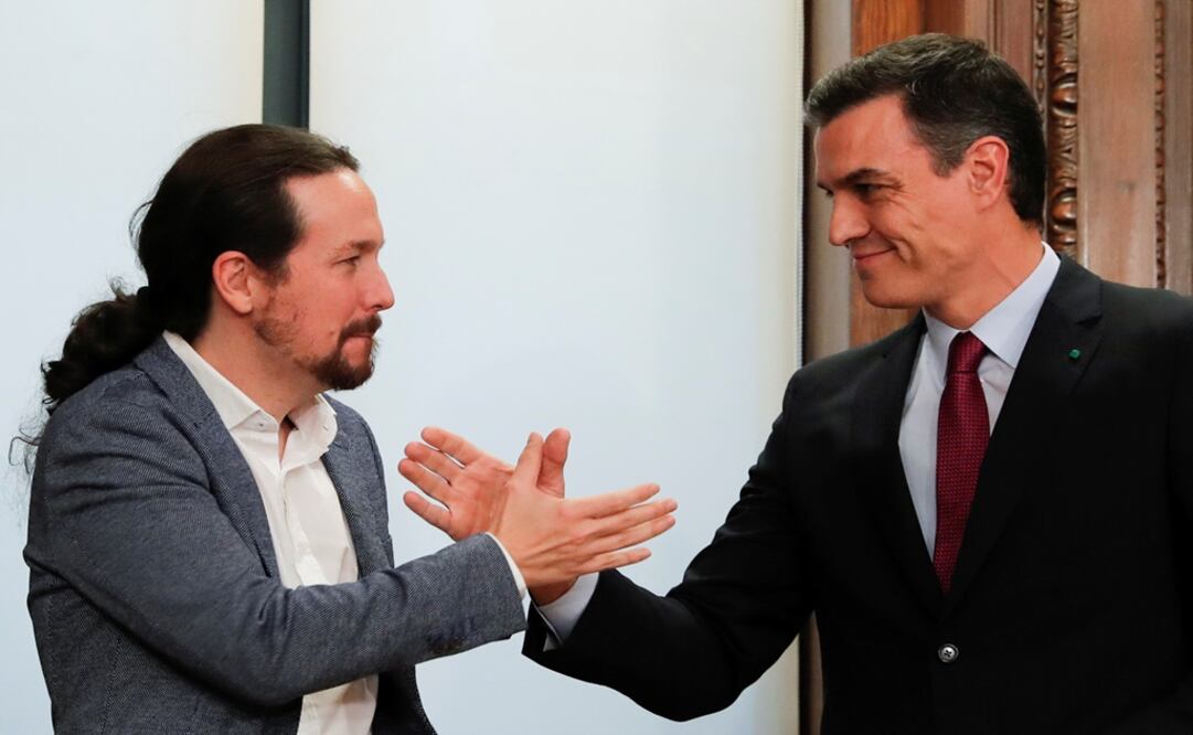 Socialist leader Pedro Sánchez and Pablo Iglesias leader of left-wing Unidas Podemos shake hands as they present their coalition agreement at Spain's Parliament - Photo: Susana Vera/