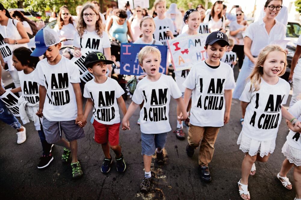 Niños se toman de las manos durante una manifestación en Washington en reclamo de la reunión de familias migrantes que fueron separadas por la administración de Donald Trump. (CARLOS BARRIA. REUTERS)