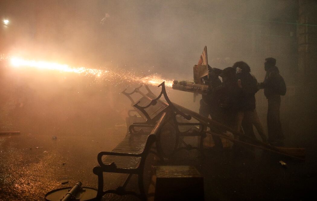 Partidarios de la oposición georgiana lanzan fuegos artificiales hacia la policía durante una protesta frente al edificio del Parlamento en Tiflis, Georgia, el 30 de noviembre de 2024. Foto: EFE