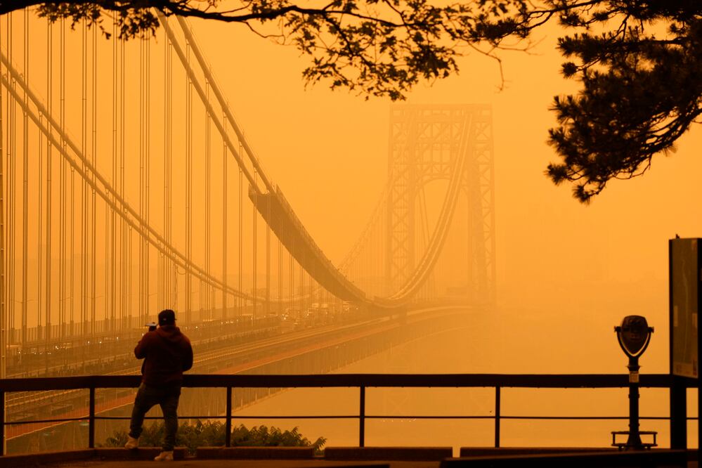 Un hombre habla por teléfono mientras observa la bruma en el puente George Washington, el miércoles 7 de junio de 2023, desde Fort Lee, Nueva Jersey. Foto: AP