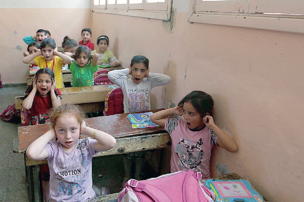 Niños sirios durante una clase en la que miembros de la seguridad les dicen cómo reaccionar ante ataques