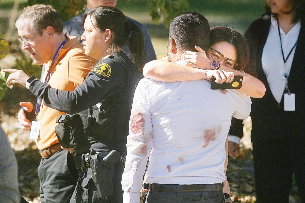 Sobrevivientes del tiroteo y familiares se abrazan, tras ser ayudados a salir del Centro Regional Inland, en San Bernardino, California (DAVID BAUMAN. XINHUA)