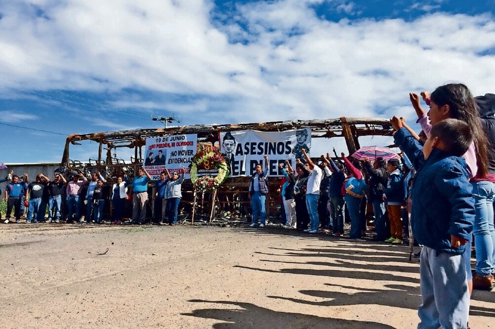 En la carretera federal 190, a la altura del panteón, maestros disidentes colocaron una ofrenda floral como homenaje a las víctimas del enfrentamiento del 19 de junio, a quienes dedicaron un minuto de aplausos (ESPECIAL)
