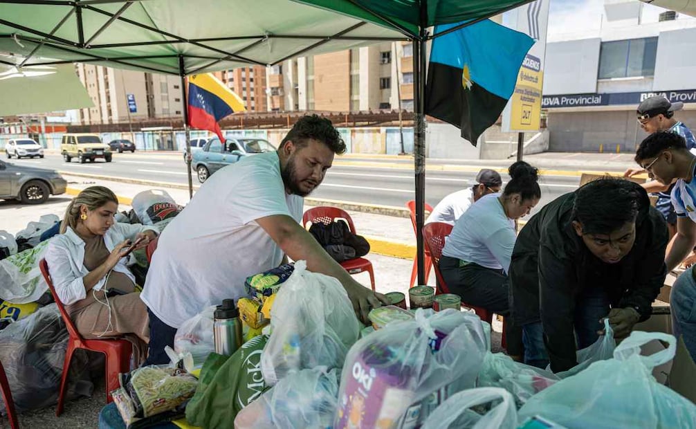 Venezolanos reparten y organizan víveres en centros de acopio. (25/06/26) Foto: EFE
