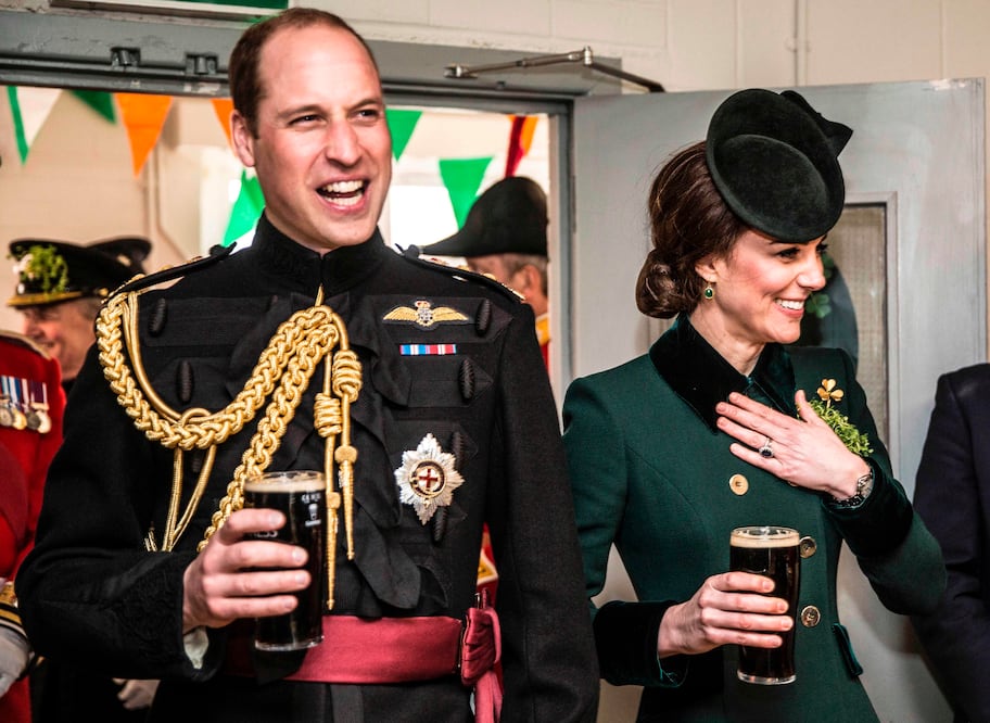 La duquesa de Cambridge y el príncipe Guillermo, sostienen una pinta de cerveza mientras hablan con los soldados fuera de servicio del 1r batallón de Guardias irlandeses, en Londres (Foto: Reuters)