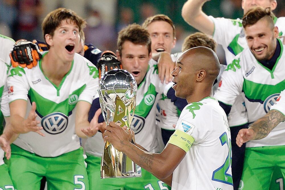 El brasileño Naldo, capitán del Wolfsburg, levanta el trofeo de campeones ante la algarabía de sus compañeros (MARTIN MEISSNER. AP)