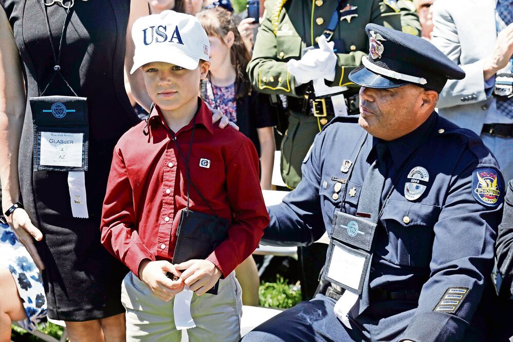 Un policía y su hijo en la ceremonia en honor a los policías muertos en acción, ayer en Washington DC. (KEVIN LAMARQUE. REUTERS)