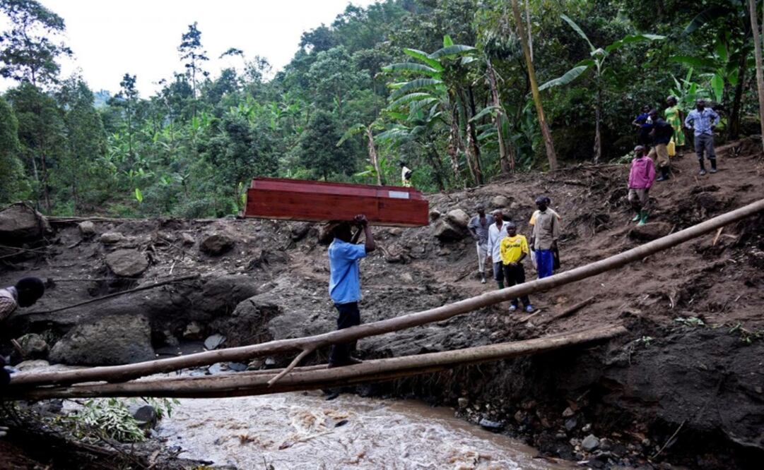 A man crosses the Sume river carrying an empty coffin on his head after a landslide rolled down the slopes of Mt. Elgon through their village of Wanjenwa in Bududa district, Uganda - Photo: Newton Nambwaya: REUTERS