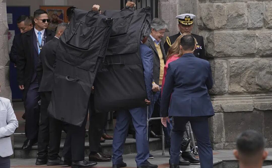 El presidente de Ecuador, Guillermo Lasso, está rodeado por agentes de seguridad cuando sale del Centro Cultural Metropolitano, ubicado junto al palacio presidencial en Quito, Ecuador. Foto: AP