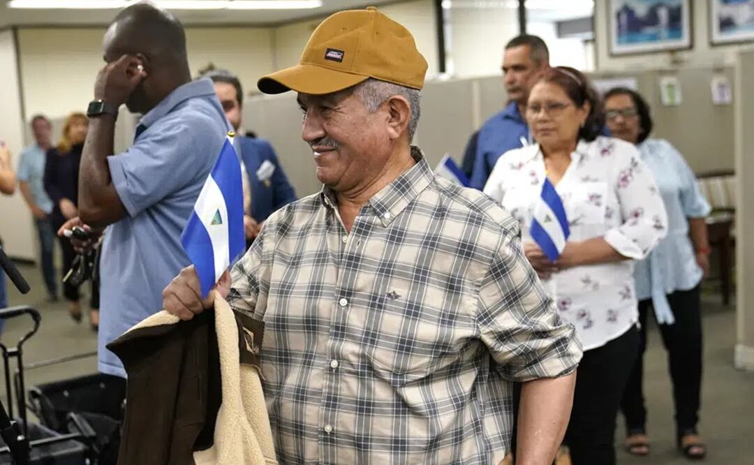 Víctor Manuel Sosa Herrera sostiene una bandera nicaragüense al llegar con otros opositores liberados en Nicaragua para una conferencia de prensa. Foto: AP