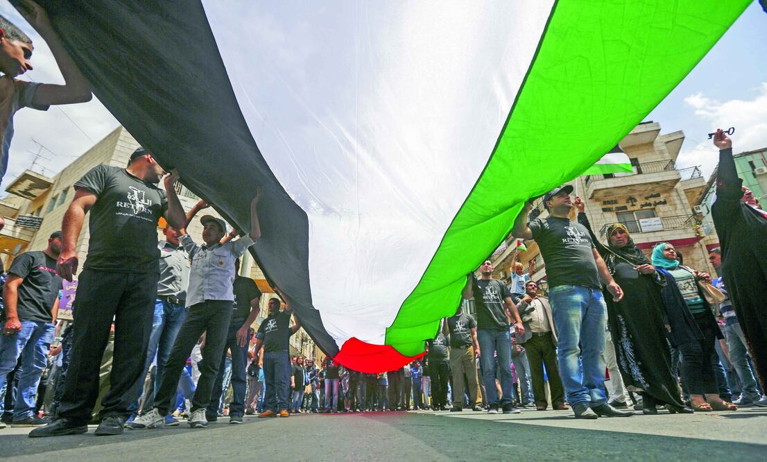 Refugiados despliegan una bandera palestina gigante durante una protesta en la ciudad cisjordana de Ramalá. Foto: ATEF SAFADI / EFE