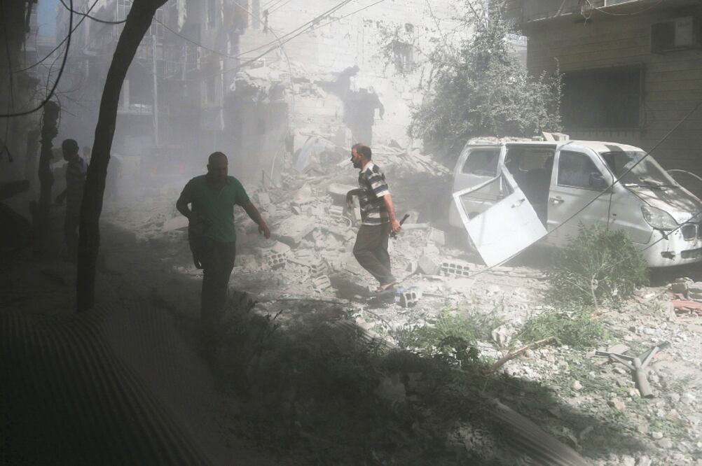 Lugareños verifican los daños ocasionados por lo que activistas describiero n como un ataque aéreo de las fuerzas leales al régimen sirio, en Duma (BASSAM KHABIEH. REUTERS)